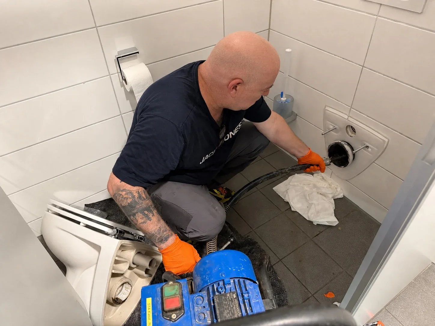 Monteur der S.T.A Kanal.-Rohrreinigung befreit ein verstopftes WC in Ulm mit der Rohrspirale